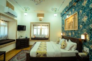 a bedroom with a bed and a mirror at Tripli Hotels Prithvi Palace in Jaisalmer