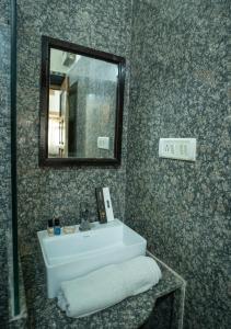 a bathroom with a white sink and a mirror at Tripli Hotels Prithvi Palace in Jaisalmer