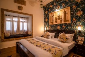 a bedroom with two beds with floral wallpaper at Tripli Hotels Prithvi Palace in Jaisalmer