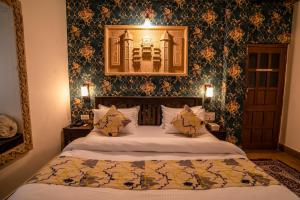 a bedroom with a bed with a picture on the wall at Tripli Hotels Prithvi Palace in Jaisalmer