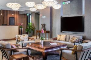 a living room with a couch and a tv at Jankovich Hotel in Rácalmás