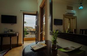 a room with a table and a view of a balcony at Tripli Hotels Prithvi Palace in Jaisalmer