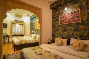 a bedroom with two beds and a mirror at Tripli Hotels Prithvi Palace in Jaisalmer