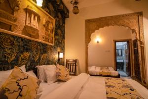 a bedroom with a bed and a mirror at Tripli Hotels Prithvi Palace in Jaisalmer