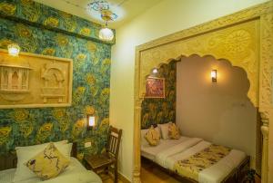two beds in a room with colorful wallpaper at Tripli Hotels Prithvi Palace in Jaisalmer