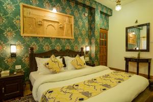 a bedroom with two beds and green wallpaper at Tripli Hotels Prithvi Palace in Jaisalmer