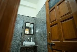 a bathroom with a sink and a mirror and a door at Tripli Hotels Prithvi Palace in Jaisalmer