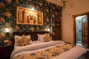 a bedroom with a large bed with floral wallpaper at Tripli Hotels Prithvi Palace in Jaisalmer