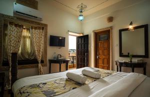 a bedroom with a large bed with two pillows on it at Tripli Hotels Prithvi Palace in Jaisalmer