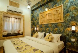 a bedroom with a bed and a wall covered in wallpaper at Tripli Hotels Prithvi Palace in Jaisalmer