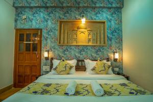 a bedroom with a large bed with blue wallpaper at Tripli Hotels Prithvi Palace in Jaisalmer