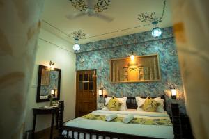 a bedroom with a bed with a blue wall at Tripli Hotels Prithvi Palace in Jaisalmer