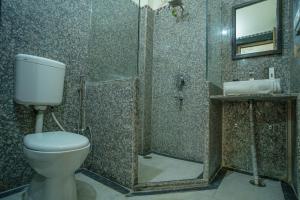 a bathroom with a toilet and a shower and a sink at Tripli Hotels Prithvi Palace in Jaisalmer