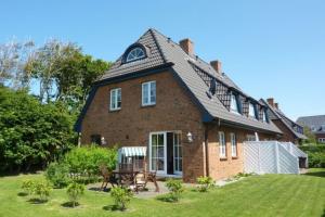 a large brick house with a gambrel roof at Wohnen auf'm Lande HT 6 in Oldsum