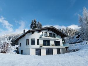 a white house in the snow at Apartmenthaus Mountainvista in Kleinarl