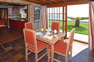 Casa El Roquito في Lodero: غرفة طعام مع طاولة وكراسي ومطبخ