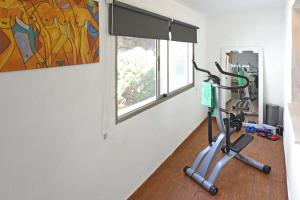 un gimnasio con bicicleta estática en una habitación con ventana en Casa El Roquito en Lodero