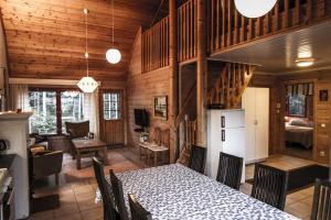 a dining room with a table and a living room at Lomakulkuri Apartments in Vuokatti