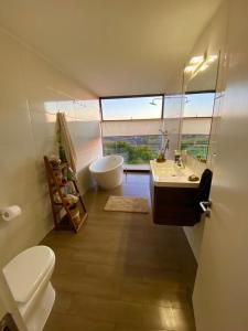 y baño con aseo, lavabo y bañera. en Hermosa y acogedora parcela cerca de viñas y playa, en Algarrobo