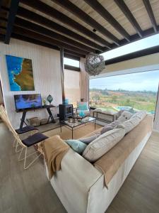 un sofá grande en una sala de estar con una ventana grande en Hermosa y acogedora parcela cerca de viñas y playa, en Algarrobo