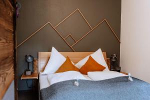 sypialnia z łóżkiem z pomarańczowymi i białymi poduszkami w obiekcie Bed and Breakfast - Das Schutzhaus - Dein Basislager im Salzkammergut w mieście Bad Aussee