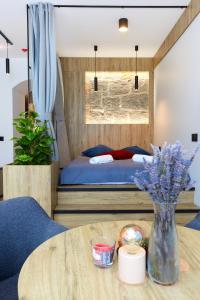 um quarto com uma cama e uma mesa com flores em Apartament "Powoli" z darmowym parkingiem em Karpacz