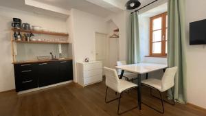kuchnia i jadalnia ze stołem i krzesłami w obiekcie Apartments Fonda House w mieście Piran