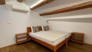 niewielka sypialnia z łóżkiem z 2 szafkami nocnymi w obiekcie Apartments Fonda House w mieście Piran