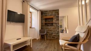 a living room with a tv and a table and a chair at Apartments Fonda House in Piran