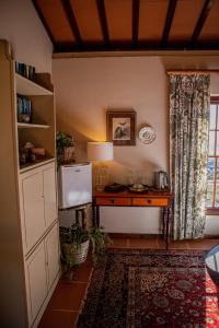 Zimmer mit einem Schreibtisch, einem Kühlschrank und einem Fenster in der Unterkunft Casa Mori House in Stellenbosch