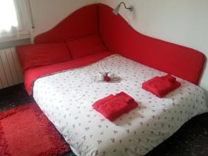 ein rotes Bett mit zwei roten Handtüchern drauf in der Unterkunft Appartamento Lily in Florenz