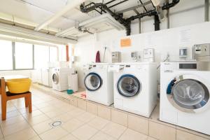 eine große Waschküche mit weißen Waschmaschinen und Trocknern in der Unterkunft Haus Meeresblick Wohnung 47 in Kellenhusen