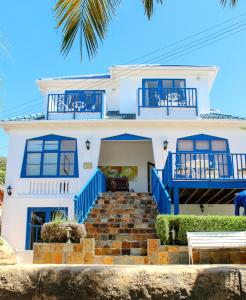 a white house with blue balconies and stairs at Port View Guest House in Cape Town