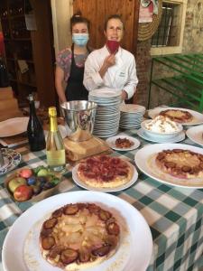 twee mensen aan een tafel met borden eten bij Palazzetto Ardi in Torri di Confine