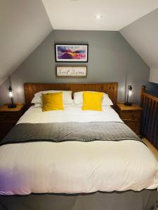 a bedroom with a large bed with yellow pillows at The Rowanberry Suite at Rowan Cottage in Elgol