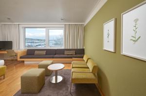 a living room with a couch and a table and chairs at Reykjavik Natura - Berjaya Iceland Hotels in Reykjavík