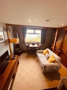 a living room with a couch and a table at The Rowanberry Suite at Rowan Cottage in Elgol +7 photos