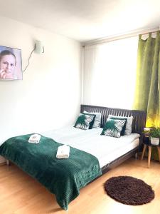 a bedroom with a bed with green sheets and a window at Studio przy Starówce in Olsztyn