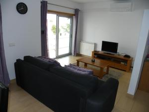 a living room with a black couch and a table at Haven in São Martinho do Porto