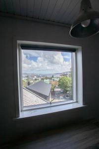 a window in a room with a view of a city at The Bird / Guesthouse / 10 min Walk Downtown in Tórshavn