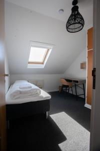 a bedroom with a bed and a desk and a window at The Bird / Guesthouse / 10 min Walk Downtown in Tórshavn