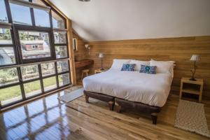 1 dormitorio con cama y ventana grande en Palafito Loft, en Castro