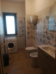 uma casa de banho com um WC e uma máquina de lavar roupa em Appartament Noemi em Ricadi