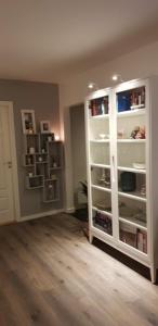 a living room with a large white book shelf at Sentralt 10 minutt med buss til Trondheim Sentrum in Trondheim