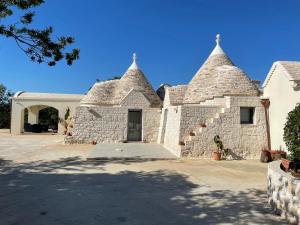 un edificio con torrette e vialetto d'accesso di La Valle dei Trulli Relais a Martina Franca