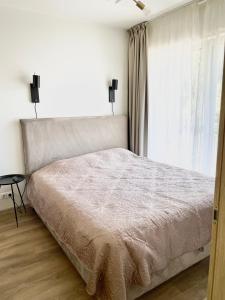 a bedroom with a large bed and a window at Palanga Apartment - Malūno Vilos in Palanga