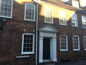 a red brick building with a door and a street sign at Elizabeth Clark in Manningtree