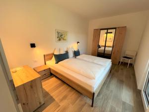 a bedroom with a large bed and a table at Apartment Ansitz Unterwinkel in Caldaro