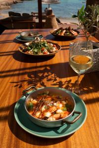 a table with a bowl of food and a glass of wine at Adams Beach Hotel & Spa in Ayia Napa