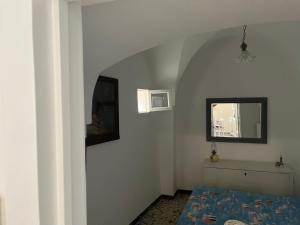 een slaapkamer met een bed en een spiegel aan de muur bij Casa Bettina in Ostuni